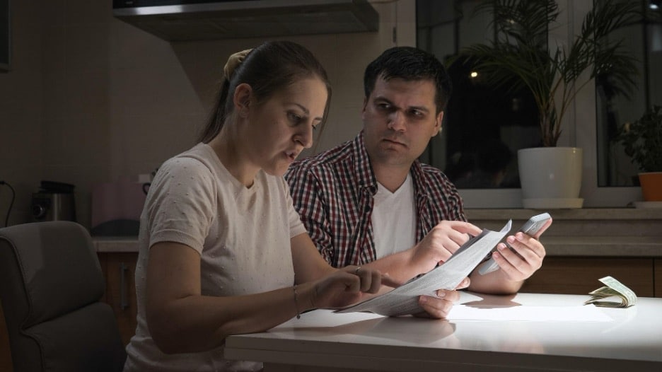Concerned Las Vegas couple reviewing a high electric bill, a warning sign their AC needs repair