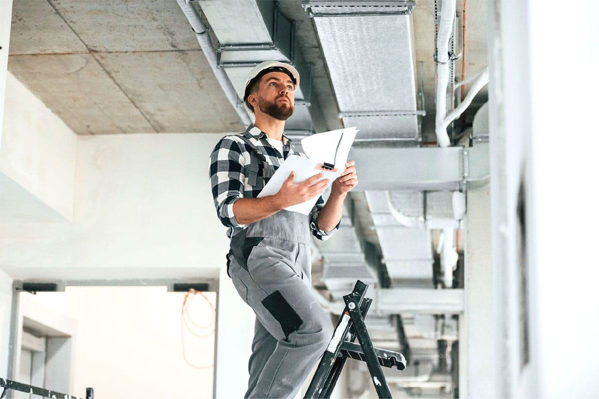 HVAC technician checking airflow at an upstairs vent in a Las Vegas two-story home
