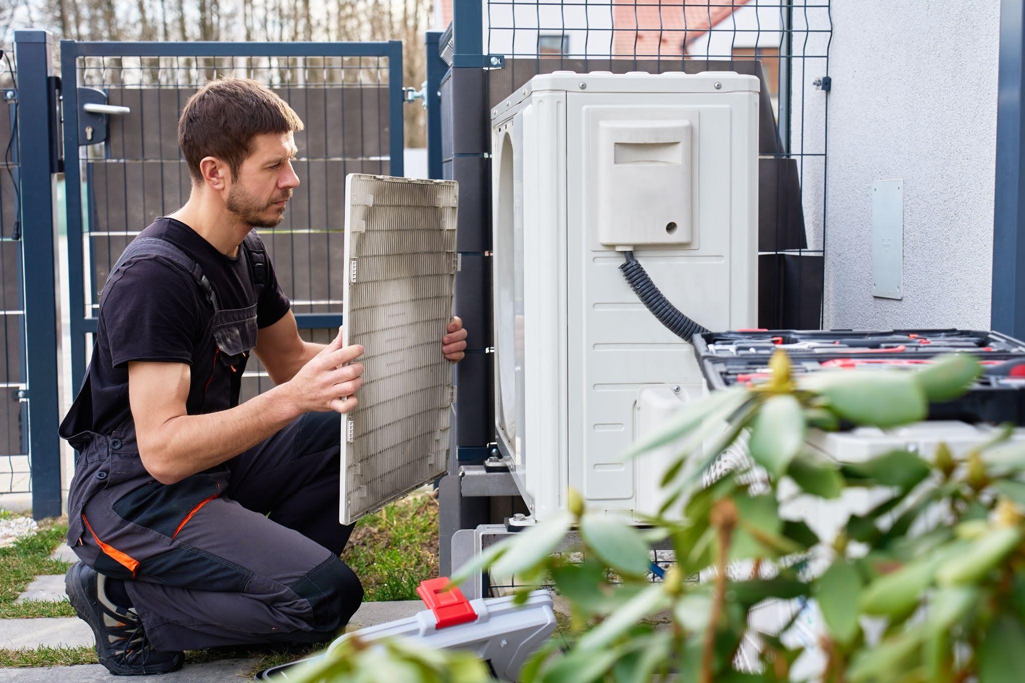 Professional HVAC Technician Servicing Outdoor Air Conditioning Unit