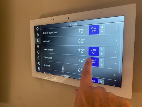 Paradise NV homeowner checking thermostat at night while AC blows warm air through vent