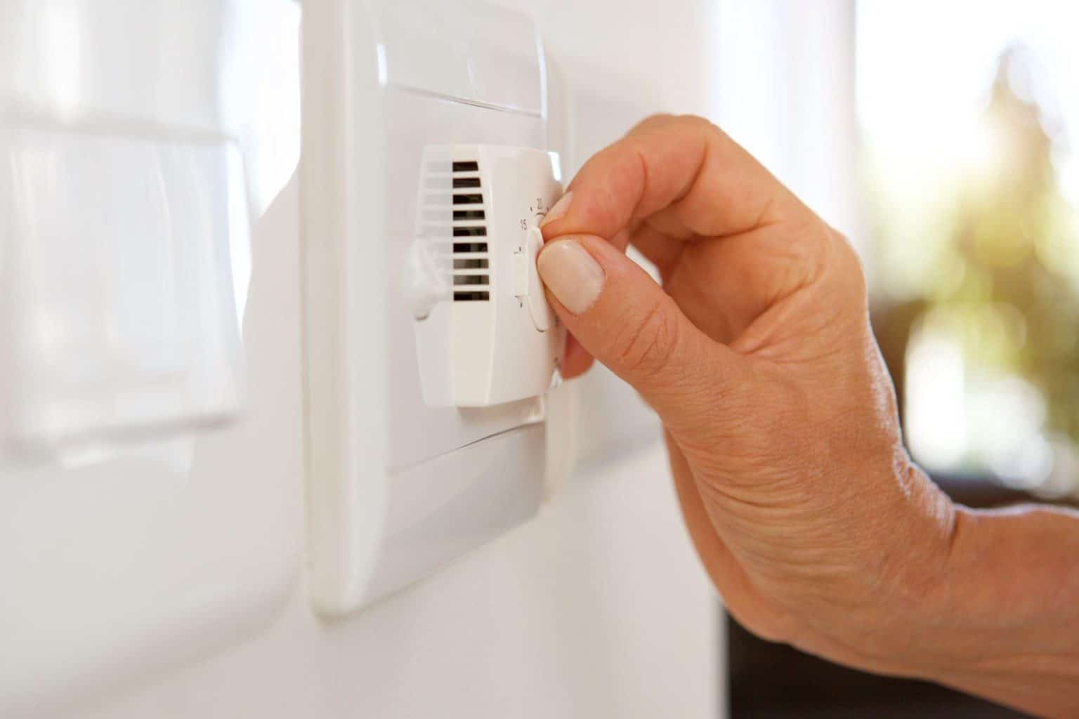 Hand Adjusting Thermostat Setting Inside Paradise, Las Vegas Home