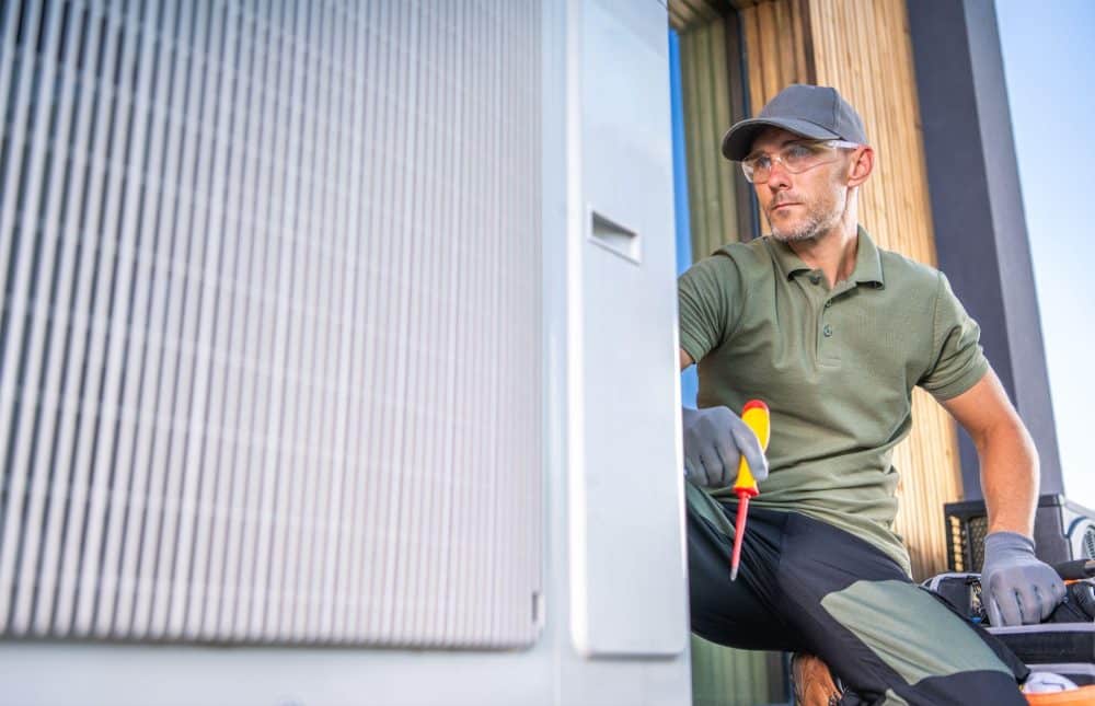 Man Repairing Air Conditioner with Tools and Expertise